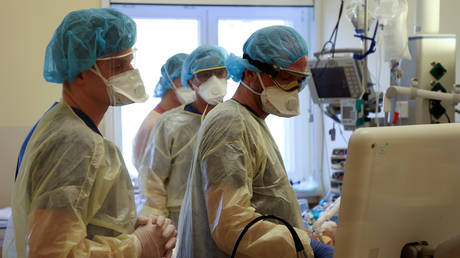 Members of the medical staff in protective suits treat a patient suffering from the coronavirus disease (COVID-19) in an intensive care unit at Havelhoehe community hospital in Berlin, Germany, April 20, 2020. © Reuters / Fabrizio Bensch
