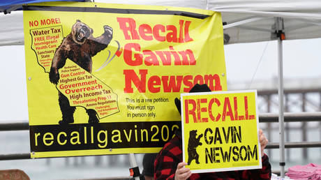 FILE PHOTO: A supporter of former U.S. President Donald Trump hides his face with a "Recall Gavin Newsom" sign at a "Patriot Rally" at Pacific Beach during the outbreak of coronavirus disease (COVID-19) in San Diego, California, U.S., February 13, 2021