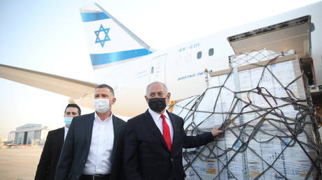 FILE PHOTO: Israel Prime Minister Benjamin Netanyahu and Health Minister Yuli Edelstein attend the arrival of a plane with a shipment of Pfizer-BioNTech vaccines © Reuters / Motti Millrod