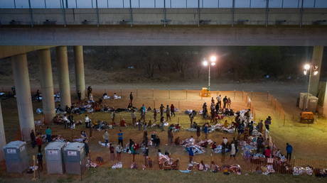 FILE PHOTO: Migrant families and unaccompanied minors take refuge in a makeshift US Customs and Border Protection processing center under the Anzalduas International Bridge after crossing the Rio Grande river into the US from Mexico, March 12, 2021