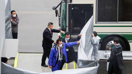 Japanese officers get prepared to escort U.S. citizens Michael Taylor and his son Peter Taylor, suspected of helping former Nissan Motor Chairman Carlos Ghosn to escape to Lebanon, upon their arrival at Narita airport, following their extradition to Japanese Prosecutors, in Chiba, Japan.