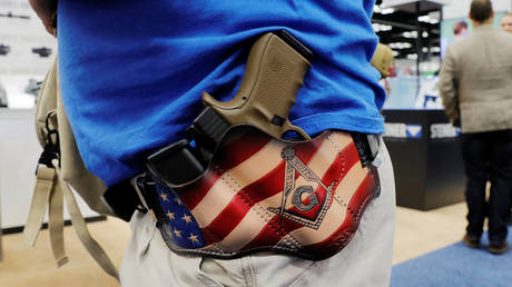 A man carries his Glock handgun in a custom holster during the National Rifle Association (NRA) annual meeting in Indianapolis, Indiana, April 27, 2019.