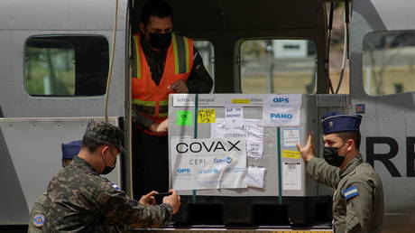 A soldier takes a picture of the batch of the AstraZeneca (SKBio Corea) vaccine delivered under the COVAX scheme against the coronavirus disease (COVID-19) at the Toncontin International Airport in Tegucigalpa, Honduras March 13, 2021. © Reuters / Fredy Rodriguez