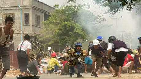 FILE PHOTO. Protesters take cover during clashes with security forces in Monywa, Myanmar on March 21, 2021.