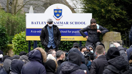 Protesters gather outside the Batley Grammar School in Batley, Britain, March 26, 2021. © Christopher Furlong / Getty Images