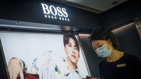 A woman walks past a Hugo Boss store in Beijing, China, March 27, 2021. Thomas Peter / Reuters