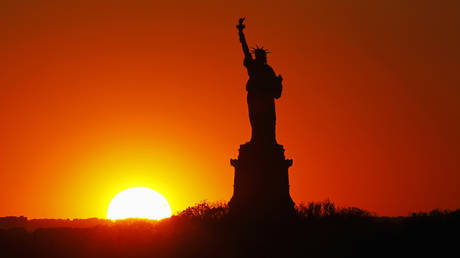 FILE PHOTO: The sun sets behind the Statue of Liberty in New York, May 26, 2013