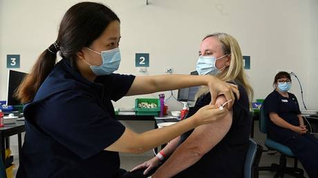 Nurse immuniser Zoe Leung (L) simulates administering a vaccine to Fiona Paine (R) at the Sydney Local Health District Vaccination Hub in Camperdown during a simulation of the COVID-19 vaccine process in Sydney on February 19, 2021. © AFP / Kate GERAGHTY