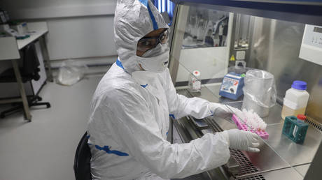 FILE PHOTO. A laboratory operator wearing a protective gear handles patients' samples in a laboratory of the National Reference Center (CNR) for respiratory viruses at the Institut Pasteur in Paris on January 28, 2020. © AFP / Thomas SAMSON