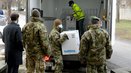 FILE PHOTO. Hungarian soldiers unload a truck with the first shipment of Pfizer-BioNTec vaccines against the novel coronavirus (Covid-19) at the South-Pest Central Hospital in Budapest on December 26, 2020. © AFP / SZILARD KOSZTICSAK