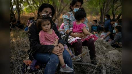 FILE PHOTO: Migrant women from Honduras are shown holding their children after crossing the Rio Grande River on rafts into the US on March 26.