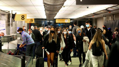 FILE PHOTO: Travelers wearing protective face masks reclaim their luggage at the airport in Denver, Colorado, November 24, 2020 © Reuters / Kevin Mohatt