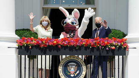 US President Joe Biden waves next to first lady Jill Biden and a person wearing an Easter Bunny costume at the Blue Room Balcony of the White House in Washington, DC, April 5, 2021.