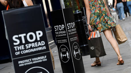 Shoppers walk past social distancing signs at the Covent Garden shopping and dining district, amid the spread of the coronavirus disease (COVID-19), in London, Britain, August 2, 2020.