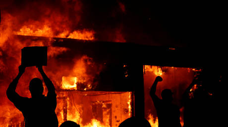 FILE PHOTO: Protesters gesture front of a fire in Minneapolis, Minnesota, May 30, 2020 © Reuters / Lucas Jackson