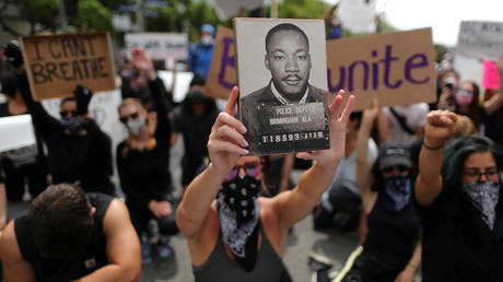 FILE PHOTO: A demonstrator holds a picture of Martin Luther King Jr. during a protest against the death in Minneapolis police custody of George Floyd, in Los Angeles, California, US June 2, 2020