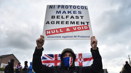 Loyalists hold up placards during an anti Northern Ireland Protocol protest against the so called Irish Sea border on April 6, 2021 in Larne, Northern Ireland.