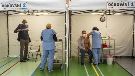 Men receive doses of a Covid-19 vaccine in the vaccination station on March 29, 2021 in Dobrichovice village, 30 km far from Prague.