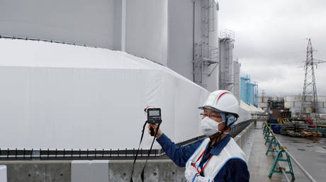 An employee of Tokyo Electric Power Co's (TEPCO) uses a geiger counter next to storage tanks for radioactive water at TEPCO's tsunami-crippled Fukushima Daiichi nuclear power plant in Okuma town, Fukushima prefecture, Japan (FILE PHOTO) © REUTERS/Aaron Sheldrick