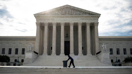 FILE PHOTO: A man wheels trash bins past the US Supreme Court building in Washington, DC, June 25, 2020 © Reuters / Al Drago