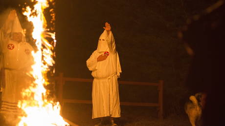 FILE PHOTO: A member of the Ku Klux Klan salutes a lit cross during a cross lighting ceremony at a private residence in Henry County, Virginia, October 11, 2014 © Reuters / Johnny Milano