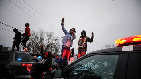 Demonstrators stand on a police vehicle during a protest after police allegedly shot and killed a man, who local media report is identified by the victim's mother as Daunte Wright, in Brooklyn Center, Minnesota, U.S., April 11, 2021.  © REUTERS/Nick Pfosi