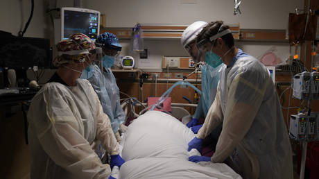 FILE PHOTO: Medical workers prepare to manually prone a COVID-19 patient in an intensive care unit at Providence Holy Cross Medical Center in the Mission Hills section of Los Angeles.