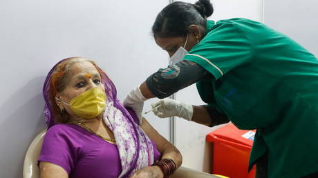 A woman reacts as she receives a dose of Covishield during the start of a four-day "Vaccination Festival" in Mumbai, India, April 11, 2021.