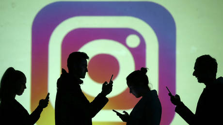 FILE PHOTO: Silhouettes of mobile users are seen next to a screen projection of Instagram logo in this picture illustration taken March 28, 2018 © Reuters / Dado Ruvic