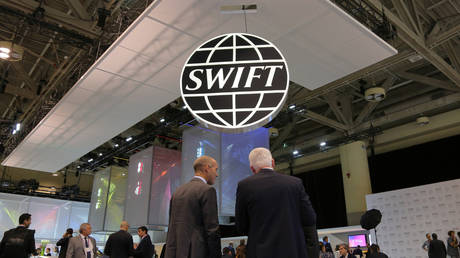 Delegates chat under the logo of global secure financial messaging services cooperative SWIFT at the SIBOS banking and financial conference in Toronto, Ontario, Canada October 19, 2017.