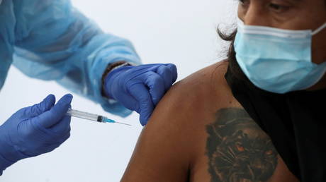 A healthcare worker administers a dose of Sinovac's CoronaVac vaccine to a person at a vaccination centre in Santiago, Chile