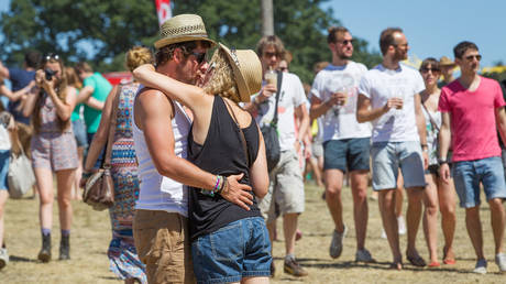 FILE PHOTO: A couple shares a tender kiss in the sunshine at The Latitude music and culture festival in Henham Park , Southwold, UK