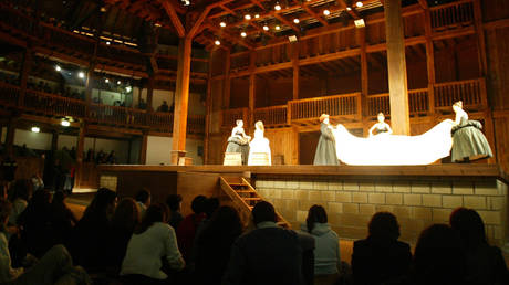 FILE PHOTO: People sit down on the ground during a performance of William Shakespeare's 'Romeo and Juliet' at Rome's new Globe Theatre