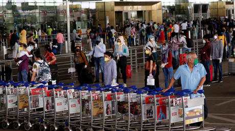 An airport staff member pushes trollies at the entrance of Chatrapati Shivaji International Airport in Mumbai, India, May 25, 2020 © Reuters / Francis Mascarenhas