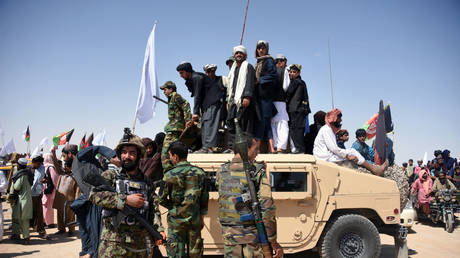 FILE PHOTO:  Afghan Taliban militants and residents stand on a armoured Humvee vehicle of the Afghan National Army (ANA) as they celebrate a ceasefire, Kandahar, Afghanistan, June 17, 2018 © AFP / Javed Tanveer