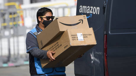 An Amazon.com Inc. delivery driver carries boxes into a van outside of a distribution facility on February 2, 2021 in Hawthorne, California.