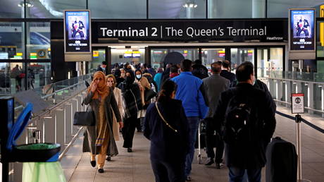 FILE PHOTO: People queue to enter terminal 2, as tighter rules for international travellers start, at Heathrow Airport.