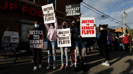 Protesters hold signs after the verdict in the trial of former Minneapolis police officer Derek Chauvin