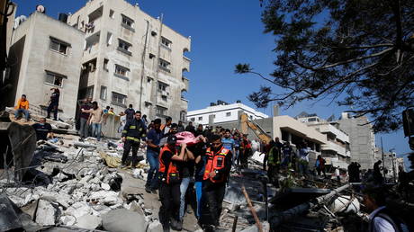 Rescue workers at the site of an Israeli airstrike in Gaza, May 16, 2021. © Mohammed Salem / Reuters