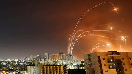 FILE PHOTO: Streaks of light are seen as Israel's Iron Dome anti-missile system intercepts rockets launched from the Gaza Strip, as seen from Ashkelon, Israel, May 12.