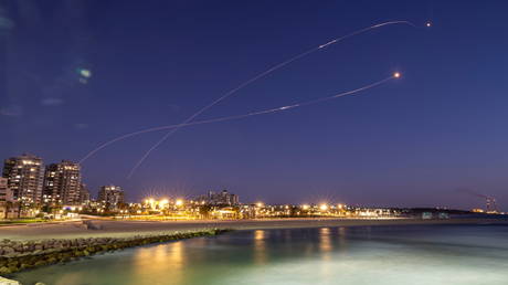 Streaks of light are seen as Israel's Iron Dome anti-missile system intercepts rockets launched from the Gaza Strip, as seen from Ashkelon, Israel, May 19, 2021.