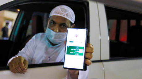 A Saudi national shows his vaccination certificate at a Bahraini Immigration check-post. © Reuters / Hamad I Mohammed