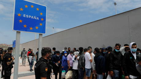 Migrants, that swam across the border during the last days, wait with residents to cross the Spanish-Moroccan border in Ceuta, Spain, (FILE PHOTO) © REUTERS/Jon Nazca