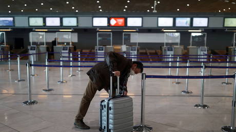 FILE PHOTO: A passenger at Charles de Gaulle Airport in Roissy, France, April 2021. © Christian Hartmann / Reuters