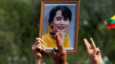 FILE PHOTO. A person holds a picture of Aung San Suu Kyi during a protest against the military coup in front of the UN office in Bangkok, Thailand.