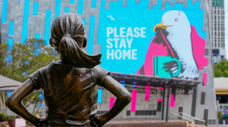 The Fearless Girl Statue looks at a "Please Stay Home" sign in an empty Federation Square on the first day of a five-day lockdown implemented in the state of Victoria in response to the coronavirus disease (Covid-19) outbreak in Melbourne, Australia, (FILE PHOTO) © REUTERS/Sandra Sanders/