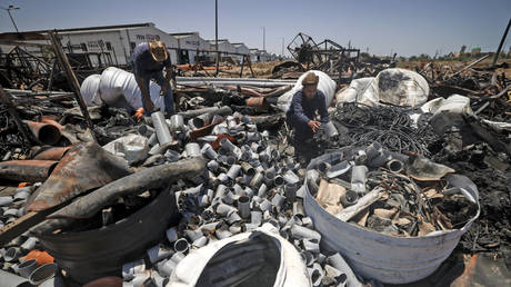 A Palestinian worker salvages items at a damaged plastic pipes factory in Gaza's industrial area, on May 25, 2021. © MAHMUD HAMS / AFP