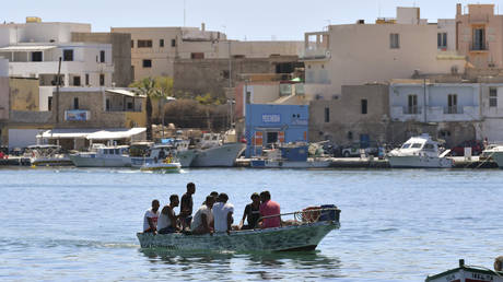 FILE PHOTO. Migrants arrive on a boat in the Italian Pelagie Island of Lampedusa.