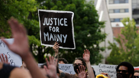 FILE PHOT: A protester holds a "Justice for Manny" sign at a march in June 2020 following the March death of Manuel Ellis in Tacoma police custody © REUTERS/Lindsey Wasson