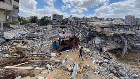 A Palestinian boy walks near a makeshift tent amid the rubble of homes destroyed by Israeli air strikes during Israeli-Palestinian fighting in Gaza, May 23, 2021.